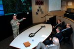 Colonel Tom Muir, left, director of the North American Aerospace Defense Command and U.S. Northern Command Command Center, briefs agency representatives attending USNORTHCOM's first State Partners Day April 25 at the commands' headquarters at Peterson Air Force Base, Colo.