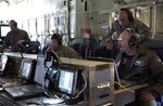 General Gene Renuart, far right, commander of North American Aerospace Defense Command and U.S. Northern Command, observes a demonstration April 17 of an airborne communications package aboard a C-130 aircraft at Peterson Air Force Base, Colo. The demonstration was conducted by the Joint Communications Support Element, a military unit composed of Army, Navy, Air Force and Marine Corps personnel, to show USNORTHCOM and civilian law enforcement organizations the communications capabilities the unit can provide to Department of Defense and other federal agencies. 