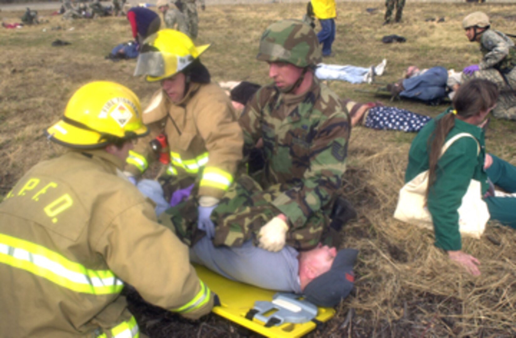Tech. Sgt. Everett Emerson, an Air National Guard medic from Kulis Air National Guard Base, Alaska, works with firefighters from the North Pole Fire Department to secure a simulated accident victim on a backboard for transportation to the Fairbanks Memorial Hospital May 9. "We've trained for mass casualty exercises, but never this big before," Sergeant Emerson said. The May 9 scenario was part of the Alaska Shield/Northern Edge 2007 exercise which is scheduled from May 7-18. Civilian, military and other government agencies are coming together for the large scale exercise which is designed to test all agencies' preparedness, interaction and response to a variety of incidents ranging from natural disasters to terrorist attacks and other emergencies. 