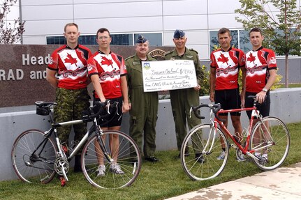 A bicycle team composed primarily of Canadian Forces and American personnel assigned to the North American Aerospace Defense Command and U.S. Northern Command rode 422 miles through the Rocky Mountains in Colorado’s annual Ride the Rockies bike ride in June 2007. The Canadians also raised $4,400 (Canadian) in donations for the "Soldier On" fund supporting injured Canadian military members. Shown here presenting the donation check to NORAD Deputy Commander Lt.-Gen. Rick Findley at NORAD and USNORTHCOM headquarters at Peterson Air Force Base, Colo., are, left to right, Canadian Forces Maj. Don Hilton, Capt. Andrew Hepburn, Findley, Col. André Dupuis, Maj. Dave Rudnicki and Maj. Mike Ashcroft. Not shown are Canadian Forces Maj. Jeff Lebouthillier and Americans Mike Ordonez and Ron Morgan. 