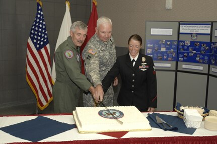 Maj. Gen. Paul Sullivan, USNORTHCOM Chief of Staff, Lt. Gen. William Webster, USNORTHCOM Deputy Commander and Petty Officer 2nd Class Angela Dickelman, the youngest member of USNORTHCOM, ceremonially cut a cake commemorating the 5th anniversary of U.S. Northern Command Oct. 1. USNORTHCOM is the joint combatant command responsible for defending the homeland and defense support of civil authorities. 