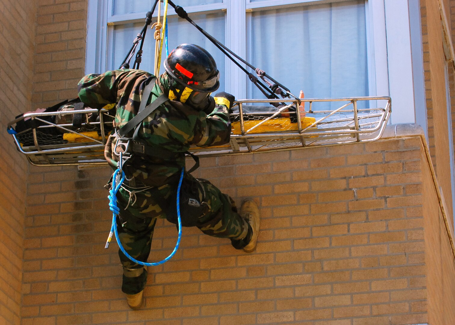 CAMP MUSCATATUCK URBAN TRAINING CENTER, Ind.— An unidentified member of the Marine Corps’ Chemical Biological Incident Force, casualty extraction team, looks down to ensure there are no obstructions as he repels down the front of a building from the roof of a four story building with a victim during the Ardent Exercise here with a dummy as a simulated victim.