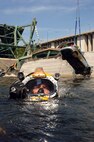 Navy Diver First Class Petty Officer Josuha Harsh of Mobile Diving and Salvage Unit Two (MDSU 2) from Naval Amphibious Base Little Creek, Virginia, surfaces after completing a salvage dive in the Mississippi river as the vehicle he and his team rigged is lifted from the bottom.  Navy divers from MDSU 2 stationed at Naval Amphibious Base Little Creek work in tandem with federal, state, and local government agencies in the search and recovery process.
