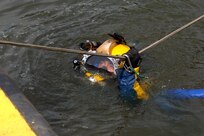 Navy Diver Second Class Petty Officer Noah Gottesman of Mobile Diving and Salvage Unit Two (MDSU 2) from Naval Amphibious Base Little Creek, Virginia, hangs off a line to stay on the surface during a salvage dive in the Mississippi river. Navy divers from MDSU 2 stationed at Naval Amphibious Base Little Creek work in tandem with federal, state, and local government agencies in the search and recovery process.