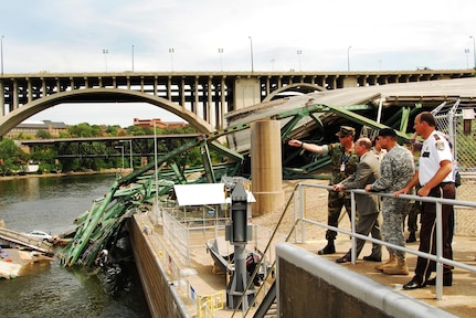 Secretary of the Navy (SECNAV) the Honorable Donald C. Winter, tours the site of the I-35 bridge collapse over the Mississippi river, with Department of Defense, federal, state, and local officials, Aug. 8. Secretary Winter was briefed on the current situation and the progress of the multi-agency search and recovery effort.