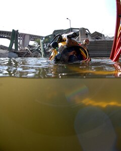 Navy Diver 1st Class William Eversmann of Mobile Diving and Salvage Unit (MDSU) 2 from Naval Amphibious Base Little Creek, Va., surfaces after a salvage dive in the Mississippi River. MDSU-2 is assisting other federal, state, and local authorities managing disaster and recovery efforts at the site of the I-35 bridge collapse. 