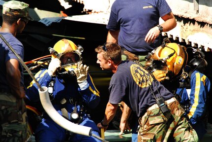 Navy divers from Mobile Dive and Salvage Unit 2 stationed at Naval Amphibious Base Little Creek prepare to enter the water of the I-35 bridge wreckage Aug. 07. When requested by the primary agency and approved by the Secretary of Defense, MDSU 2 may be utilized in support of civil authorities managing disaster recovery efforts. U.S. Navy photo by Mass Communication Specialist Seaman Joshua Adam Nuzzo  