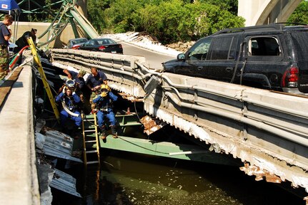 Navy divers from Mobile Dive and Salvage Unit 2 stationed at Naval Amphibious Base Little Creek prepare to enter the water of the I-35 bridge wreckage Aug. 07. When requested by the primary agency and approved by the Secretary of Defense, MDSU 2 may be utilized in support of civil authorities managing disaster recovery efforts. U.S. Navy photo by Mass Communication Specialist Seaman Joshua Adam Nuzzo (RELEASED)
 