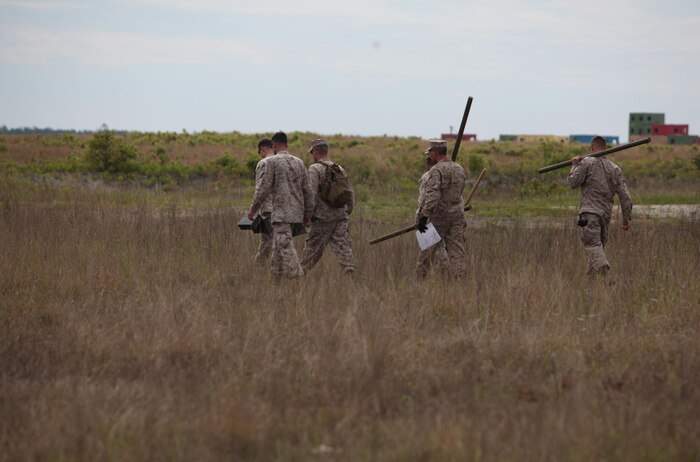 Marines with Ammunition Company, 2nd Supply Battalion, 2nd Marine Logistics Group and explosive ordnance disposal, or EOD, technicians carry unserviceable ammunition such as Bangalore torpedoes during an EOD, exercise aboard Camp Lejeune, N.C., May 7, 2013. The EOD Marines assisted servicemembers with Ammunition Co. arranging the explosives in a safe manner prior to detonation. 