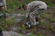 A Marine with Ammunition Company, 2nd Supply Battalion, 2nd Marine Logistics Group aboard Camp Lejeune, N.C. prepares to lift a M-107 155 millimeter projectile before placing it with other explosives destined to be destroyed, May 7, 2013. The M-107s, which were among hundreds of pounds of explosives, were no longer safe to fire in training or combat operations and were slated for demolition.