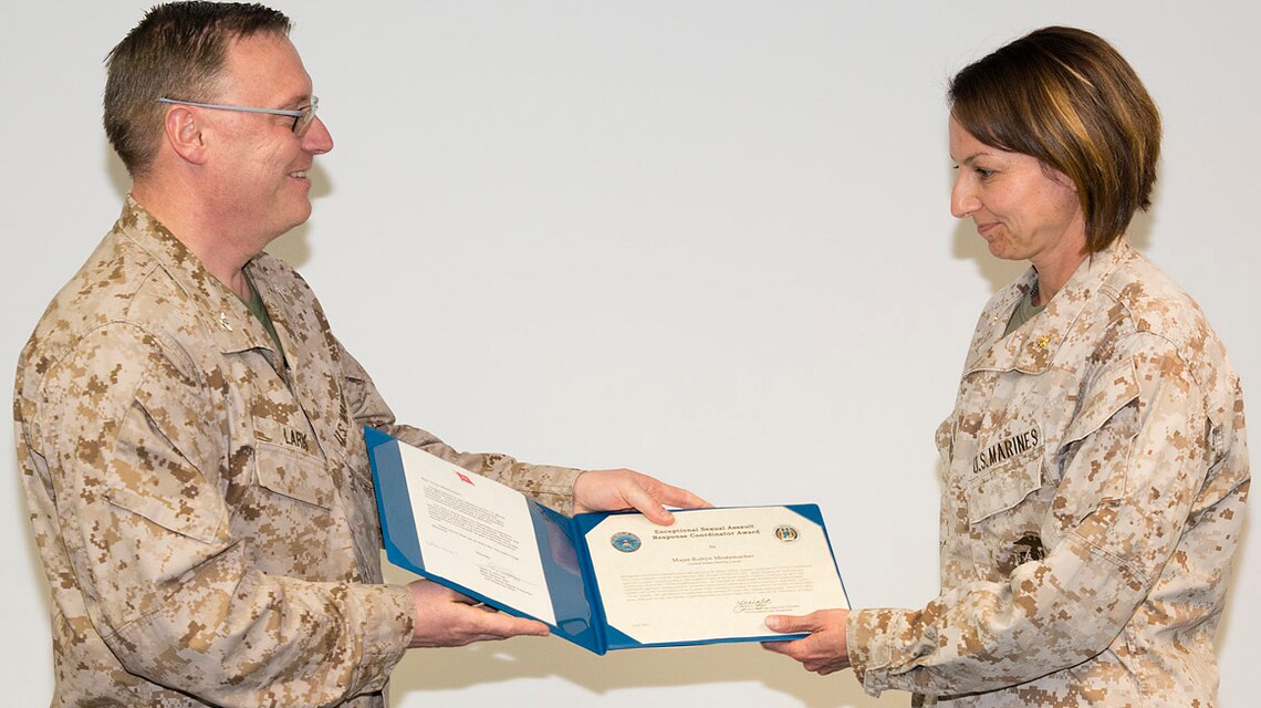 Marine Corps Maj. Robyn Mestemacher, right, accepts her award from Marine Corps Col. Philip Lark, commandant of the Marine Corps chair at the George C. Marshall European Center for Security Studies in Garmisch-Partenkirchen, Germany, on May 10, 2013. 
