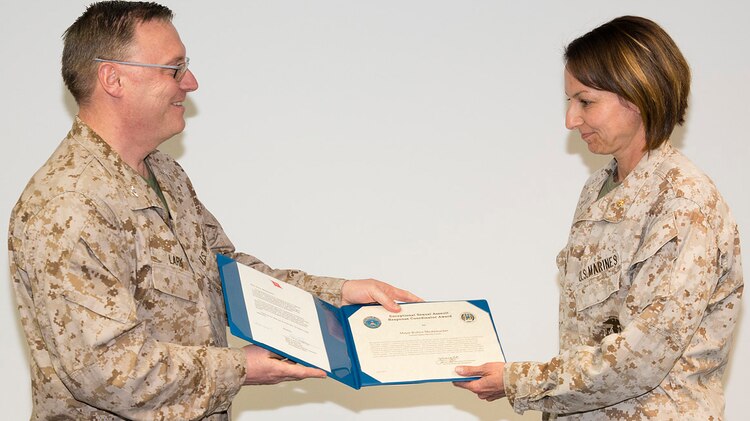 Marine Corps Maj. Robyn Mestemacher, right, accepts her award from Marine Corps Col. Philip Lark, commandant of the Marine Corps chair at the George C. Marshall European Center for Security Studies in Garmisch-Partenkirchen, Germany, on May 10, 2013. 