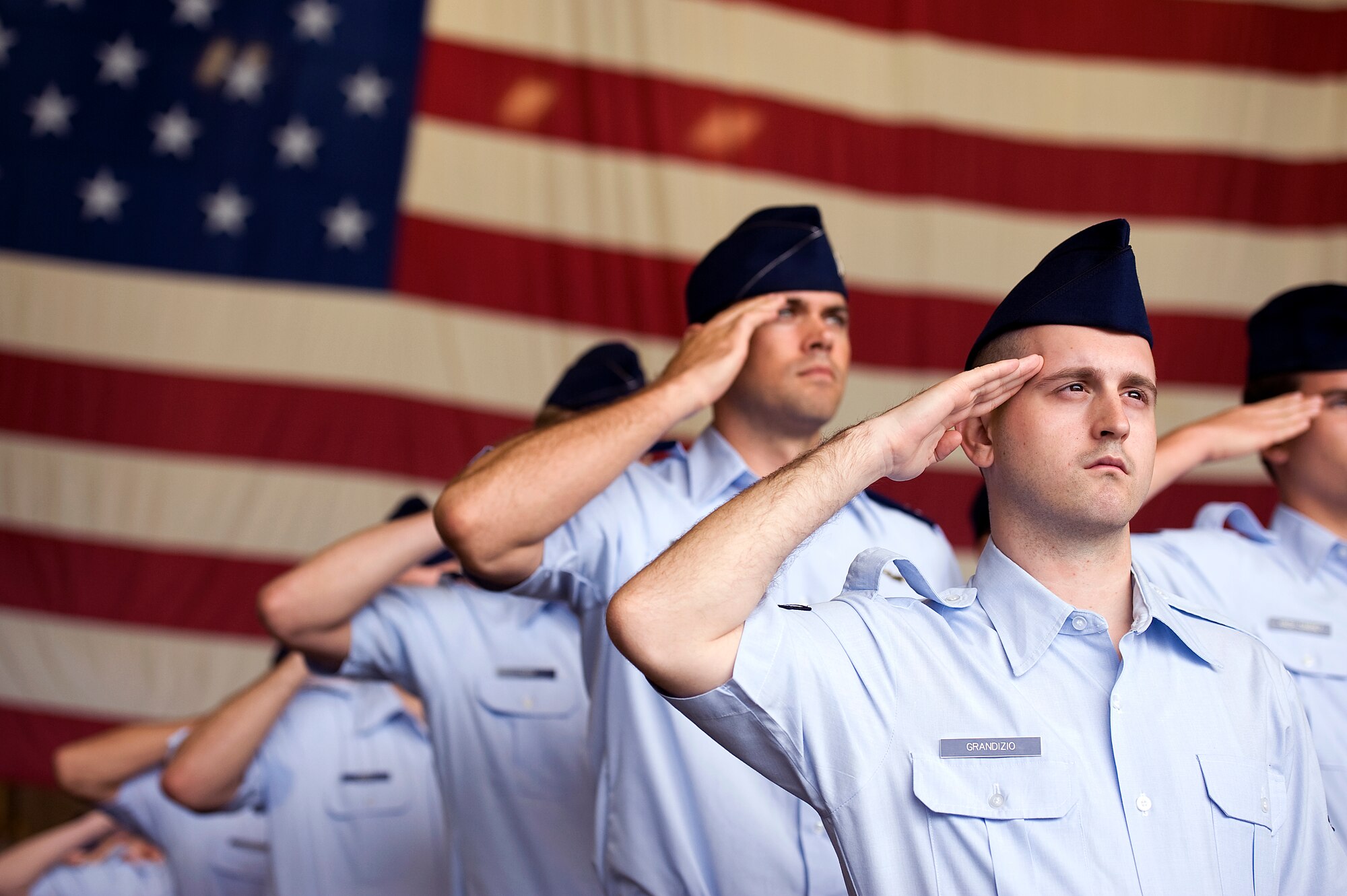 U.S. Air Force Airmen from the 18th Operations Group render a salute to the American flag during the singing of the "Star Spangled Banner" at the 18th Wing change of command ceremony on Kadena Air Base, Japan, May 13, 2013. With 8,000 Airmen assigned, the 18th Wing operates a fleet of 81 combat-ready aircraft to perform air superiority, aerial refueling, airborne warning and control, and combat search and rescue functions. (U.S. Air Force photo by Senior Airman Maeson L. Elleman/Released)
