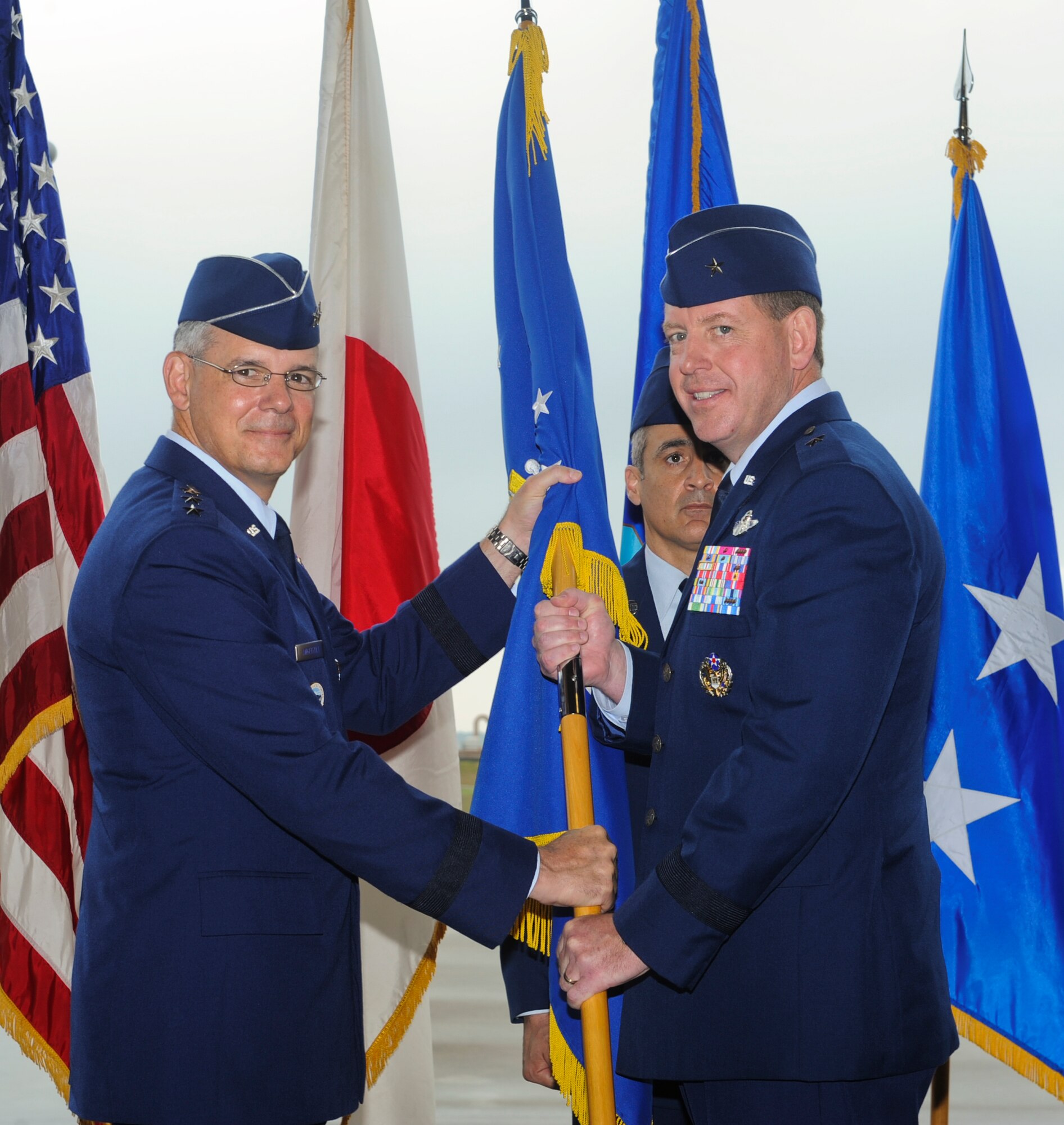 U.S. Air Force Brig. Gen. James Hecker, 18th Wing commander, receives the guidon from Lt. Gen. Salvatore Angelella, U.S. Forces, Japan, and 5th Air Force commander, during the 18th Wing change of command ceremony on Kadena Air Base, Japan, May 13, 2013. Hecker most recently served as the commander of the 432nd Wing and 432nd Air Expeditionary Wing, Creech Air Force Base, Nev. (U.S. Air Force photo by Airman 1st Class Justin Veazie/Released)