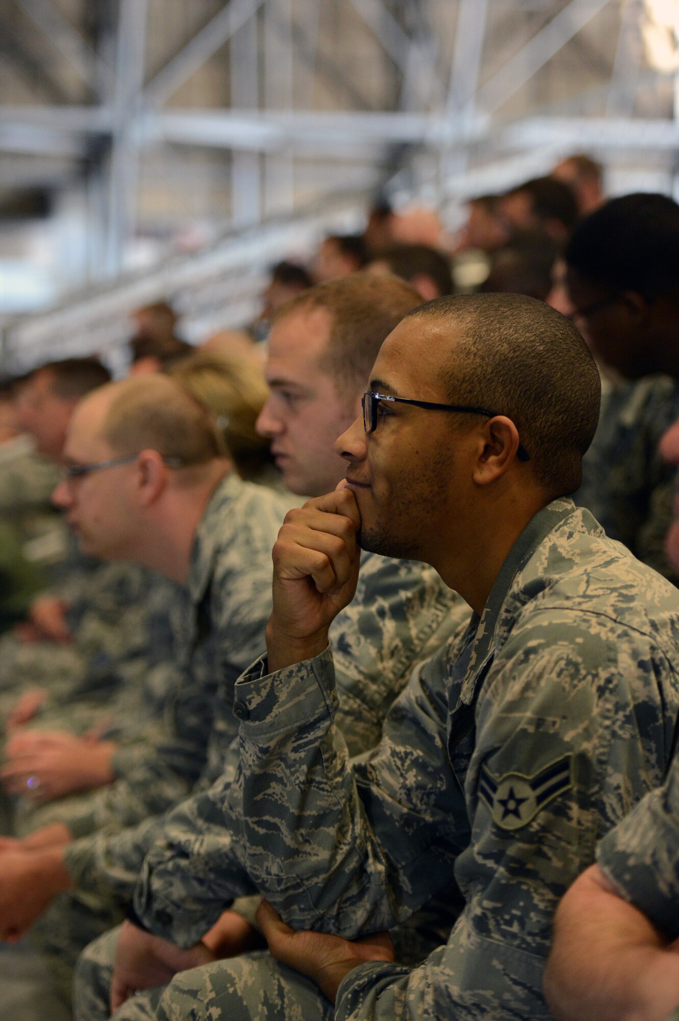 Airman 1st Class Jerrod Plummer, 62nd Operations Support Squadron air traffic control apprentice, listens as speakers share their life experiences May 10, 2013 during Wingman Day at Joint Base Lewis-McChord, Wash. Airmen gathered inside Hangar 3 and listened to several individuals speak about challenges they have faced during their lives and how they were able to bounce back. (U.S. Air Force photo/Staff Sgt. Jason Truskowski)