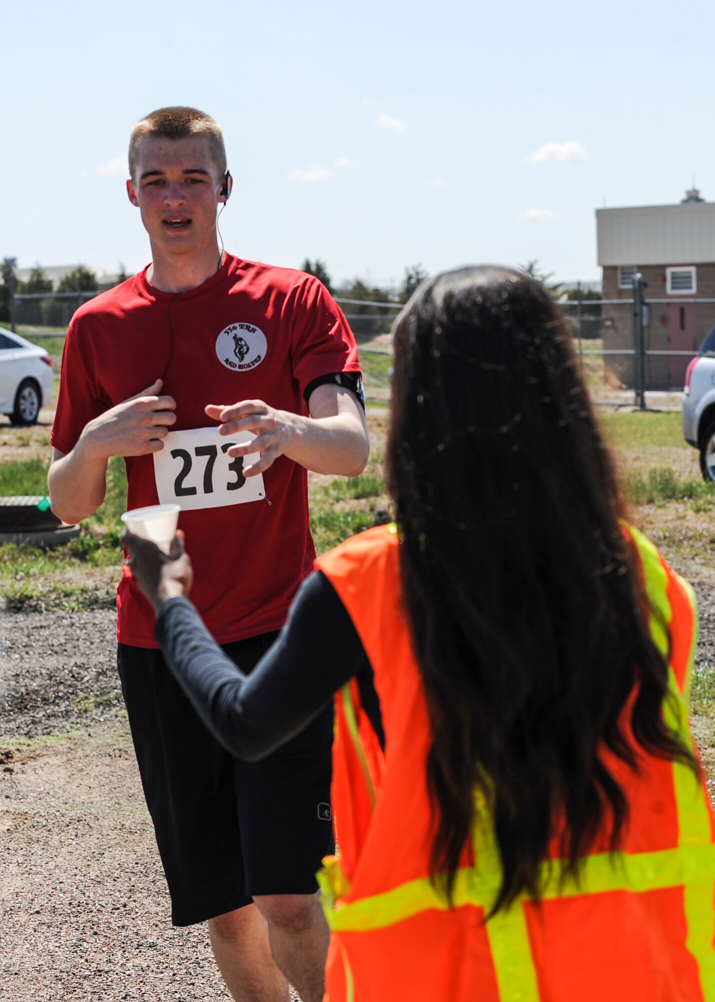 Rick Van Seters, an airman first class with the 460th Space Communications Squadron, takes a cup of water from Andrea McClew, a volunteer, at the last water station during the 7th Annual Buckley Half Marathon May 11, 2013, on Buckley Air Force Base Colo. Van Seters was one of about 50 runners who participated in the 13.1-mile race. (U.S. Air Force photo by Staff Sgt. Christopher Gross/Released)
