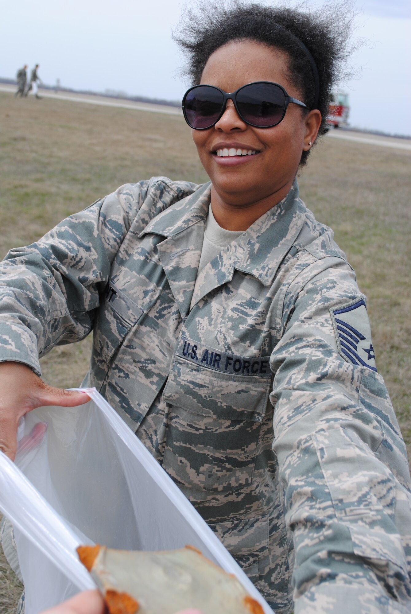 Master Sgt. Shanda Kent, 319th Air Base Wing NCO in charge of chapel  operations, helps dispose of garbage during a FOD (foreign object or debris) walk conducted on May 10, 2013, on the flightline at Grand Forks Air Force Base, N.D. A FOD walk is a large-scale inspection conducted by a long line of people walking side-by-side to identify and remove foreign objects and debris from a flightline that may cause damage to aircraft systems, weapons or injury to personnel. (U.S. Air Force photo/Staff Sgt. Luis Loza Gutierrez)
