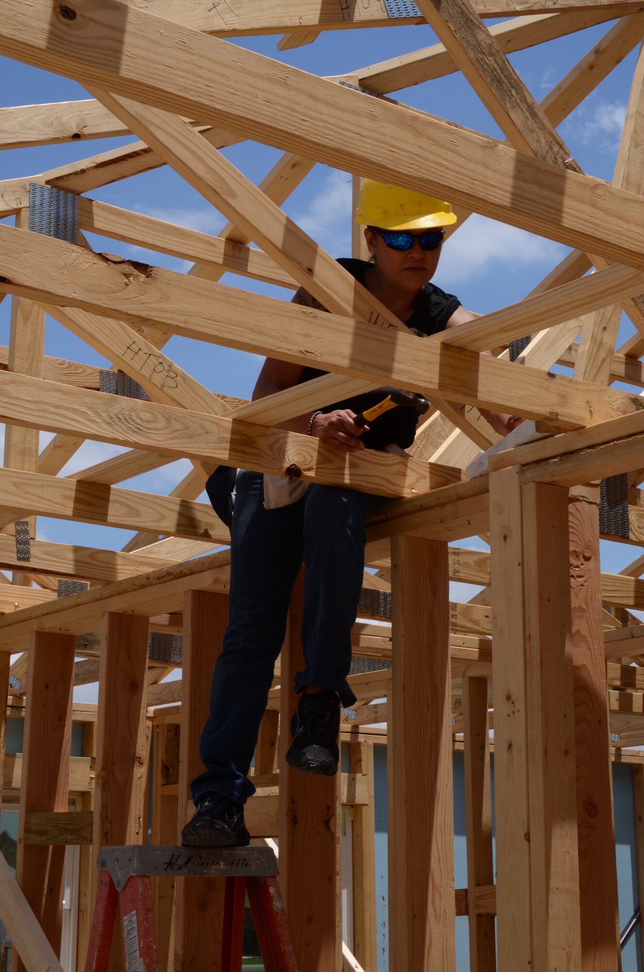 Senior Master Sgt. Vickie Padello, Air Force Recruiting Service, nails in a support board in a Habitat for Humanity home under construction in San Antonio, Texas May 11. Several members of AFRS volunteered their Saturday to assist Habitat for Humanity. The house is scheduled for completion in August. Habitat for Humanity seeks volunteers to help build and landscape affordable homes for qualified low-income families. (U.S. Air Force photo/Staff Sgt. Hillary Stonemetz)