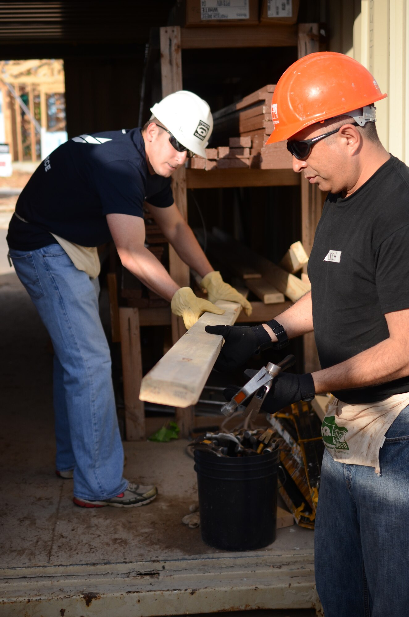 Master Sgt. Matthew Cramer (left) and Major Tenoch Aztecati, members of Air Force Recruiting Service, gather supplies to build a Habitat for Humanity home  in San Antonio, Texas May 11. Several members of AFRS worked on the home on the second day of the build. The house is scheduled for completion in August. Habitat for Humanity seeks volunteers to help build and landscape affordable homes for qualified low-income families. (U.S. Air Force photo/Staff Sgt. Hillary Stonemetz)