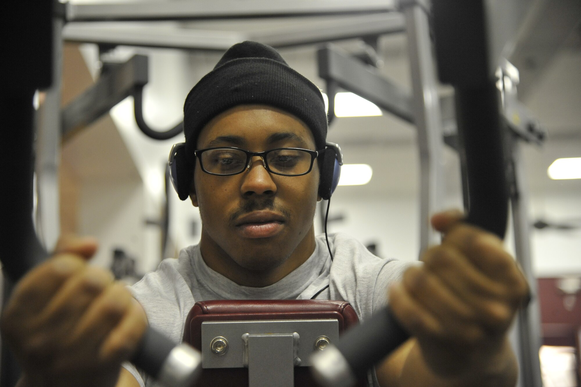 Senior Airman Adrian Paisley, 509th FSS fitness specialist, pulls on pull-down bars at the fitness center on Whiteman Air Force Base, April 22, 2013. Setting a daily routine is an excellent way to maintain good fitness and health. Relieving stress and getting fit can play a vital role in overcoming every day endeavors. (U.S. Air Force photo by Airman 1st Class Keenan Berry/Released)
