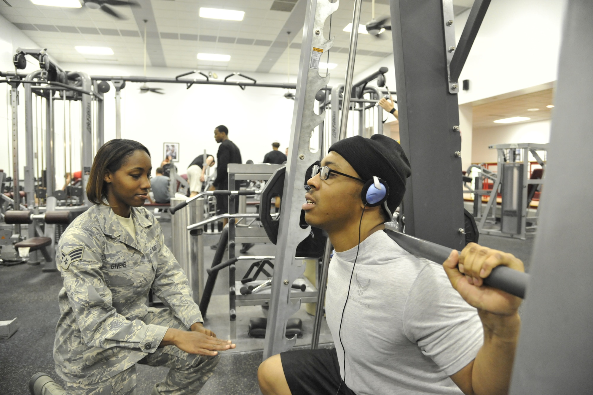 Senior Airman Melissa Givens, 509th Force Support Squadron fitness specialist, assists Senior Airman Adrian Paisley, 509th FSS fitness specialist, with squatting at the fitness center on Whiteman Air Force Base, April 22, 2013. Fitness center personnel emphasize the importance of safety to the general population every day to ensure a healthy environment. (U.S. Air Force photo by Airman 1st Class Keenan Berry/Released)