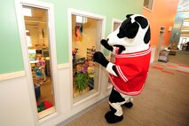 The Chick-fil-A mascot walks down the Child Daycare Center hallway to greet children as part of a Daycare Provider Day donation of 154 prepared lunches to be given to the daycare staff members on May 8 at Offutt Air Force Base, Neb.  The meals included a sandwich, chips, cookie and a choice of sweet or unsweetened tea.  (U.S. Air Force photo by Josh Plueger/Released)