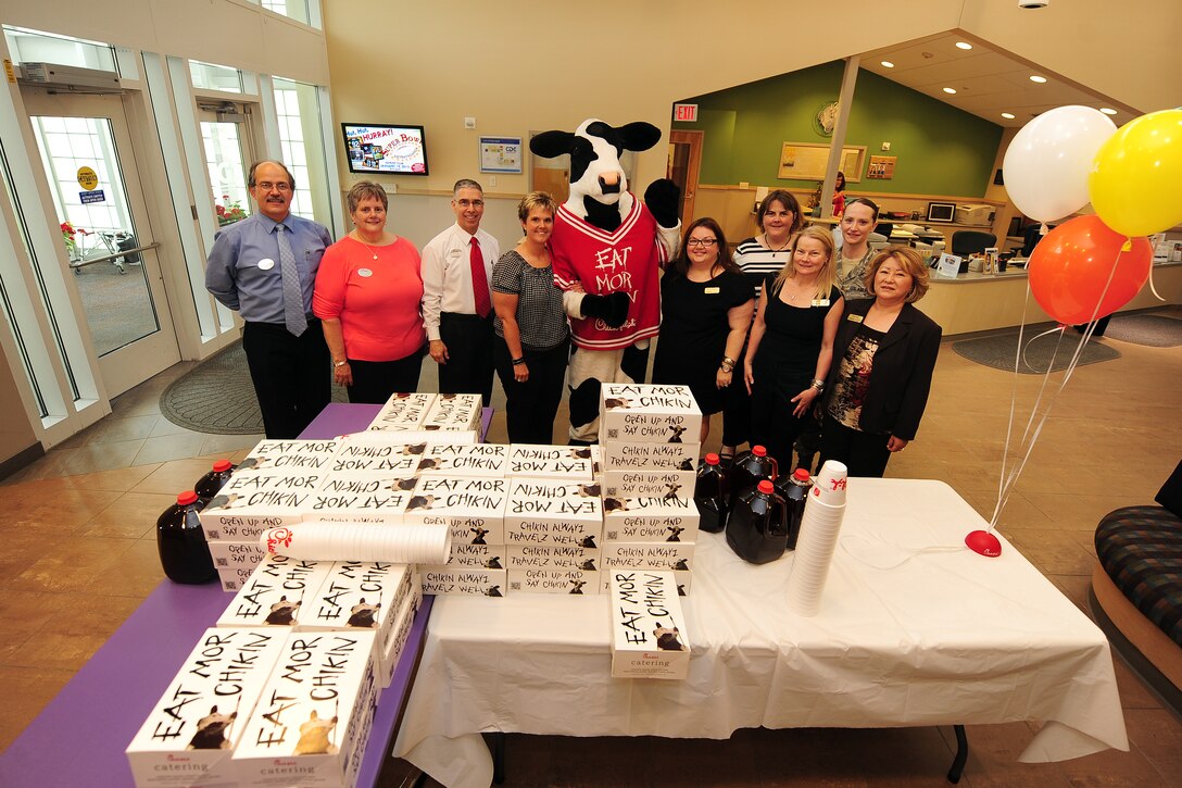 Child Daycare Center staff members stand side by side with members of Chick-fil-A catering for a group photo behind an airplane model constructed of dozens of boxed meals to be handed out to daycare staff members as a way to say thank you for the work they do on May 8 at Offutt Air Force Base, Neb.  Daycare provider day is held annually in May.  (U.S. Air Force photo by Josh Plueger/Released)