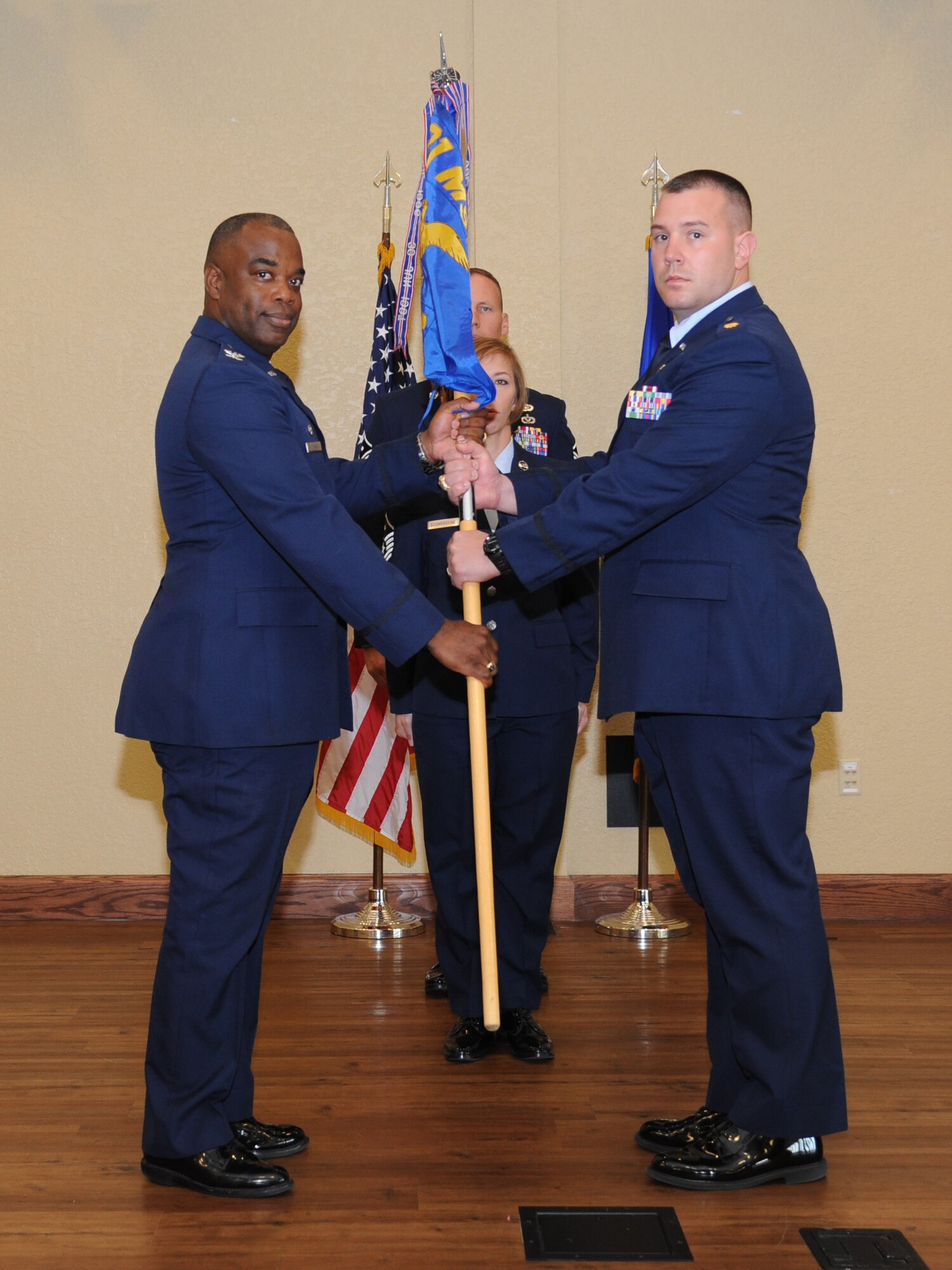 Col. Mark Vivians, 81st Mission Support Group commander, and Maj. Brian Fitzpatrick, incoming 81st SFS commander, exchange the guidon as Fitzpatrick assumes command during the 81st SFS change of command ceremony May 13, 2013, at the Bay Breeze Event Center, Keesler Air Force Base, Miss.  Maj. Matthew Pignataro, outgoing 81st SFS commander, relinquished his command to Fitzpatrick and Col. Mark Vivians, 81st Mission Support Group commander, served as the presiding officer for the event.  (U.S. Air Force photo by Kemberly Groue)