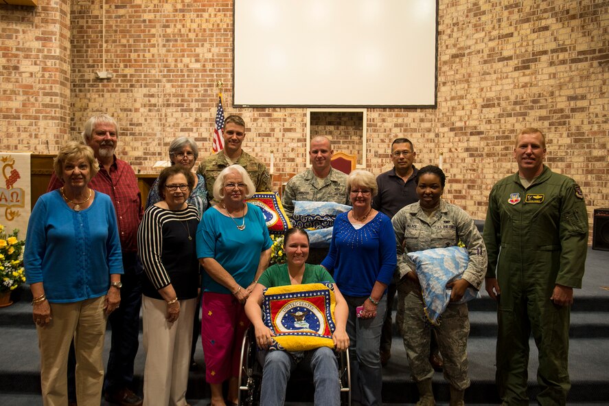 Airmen and local quilters pose for a photo May 8, 2013, at Moody Air Force Base, Ga. The quilters, who visited from Coolidge, Hahira and Quitman, Ga., presented quilts to five Purple Heart Medal recipients. (U.S. Air Force photo by Staff Sgt. Jamal D. Sutter/Released) 