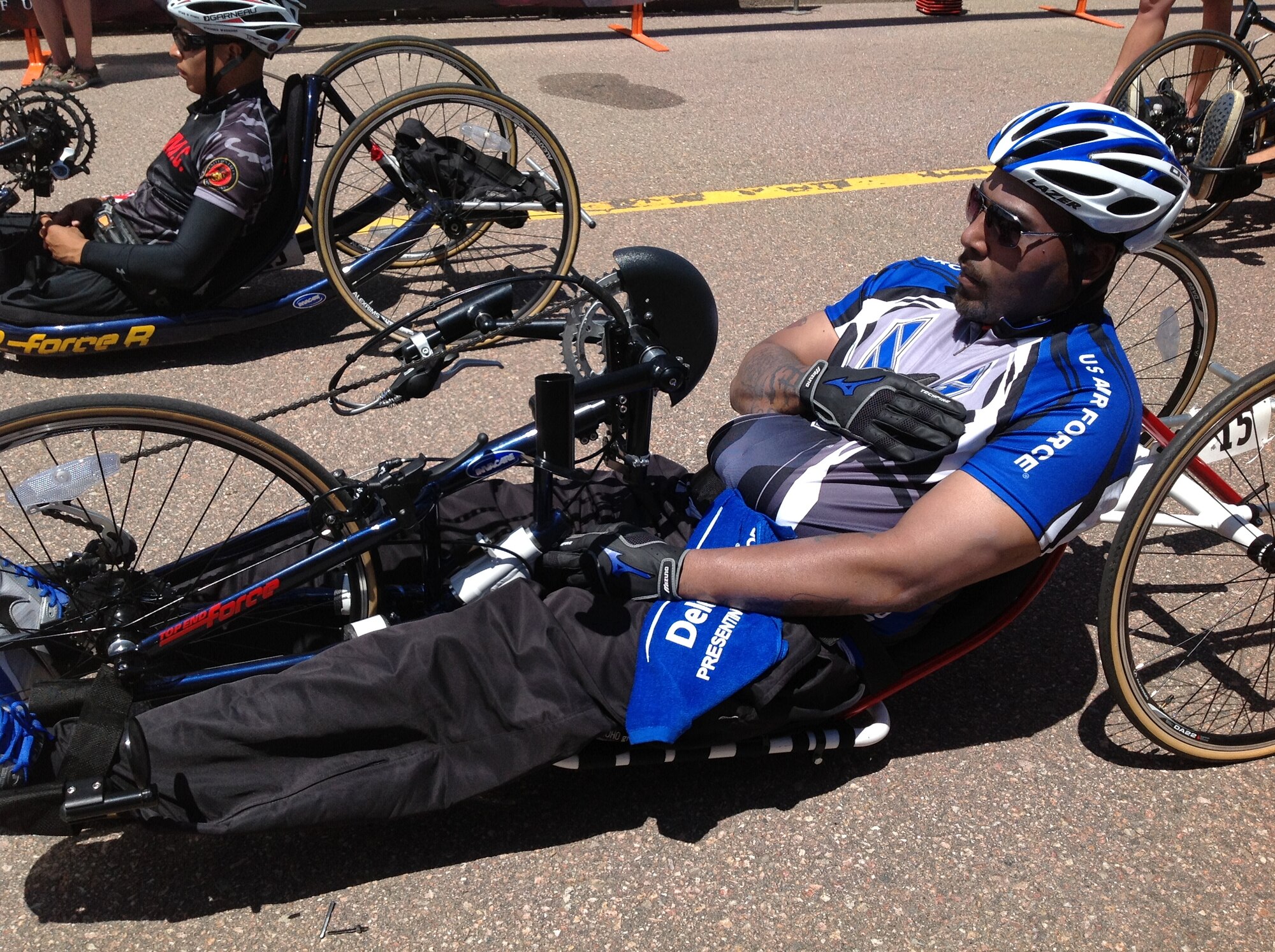 Air Force cyclist Darrell Fisher places his right hand over his heart as the British and U.S. National anthems are sung May 12 at Falcon Stadium during the 2013 Warrior Games.