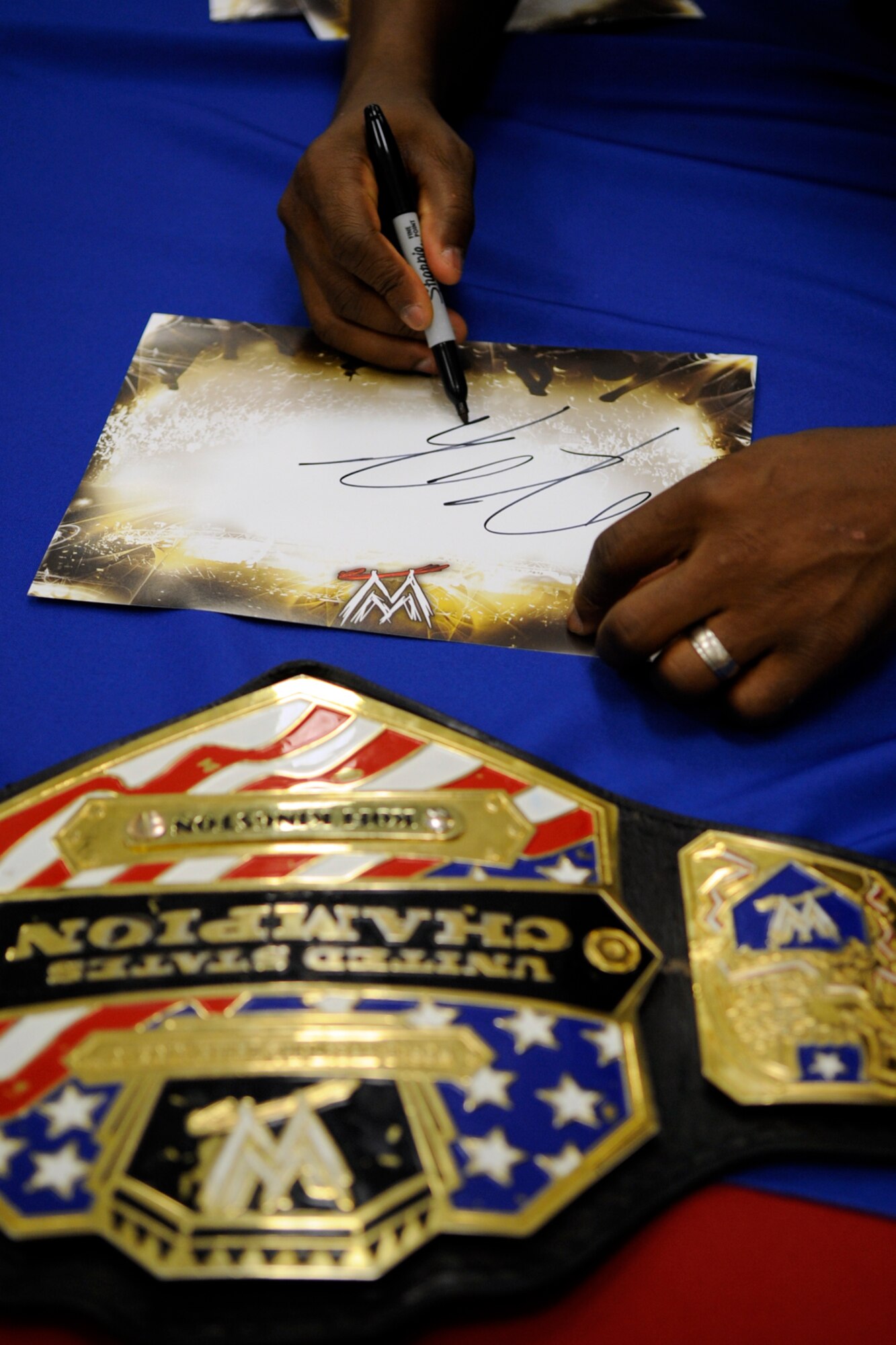 WWE Superstar and United States Champion Kofi Kingston signs autographs for his fans during a “meet and greet the troops” event at the Base Exchange on Barksdale Air Force Base, La., May 10, 2013. Later that evening, Kingston defeated Cody Rhodes during a WWE Smackdown event at the Hirsch Memorial Coliseum in Shreveport, La. (U.S. Air Force photo by Master Sgt. Jeff Walston/Released)