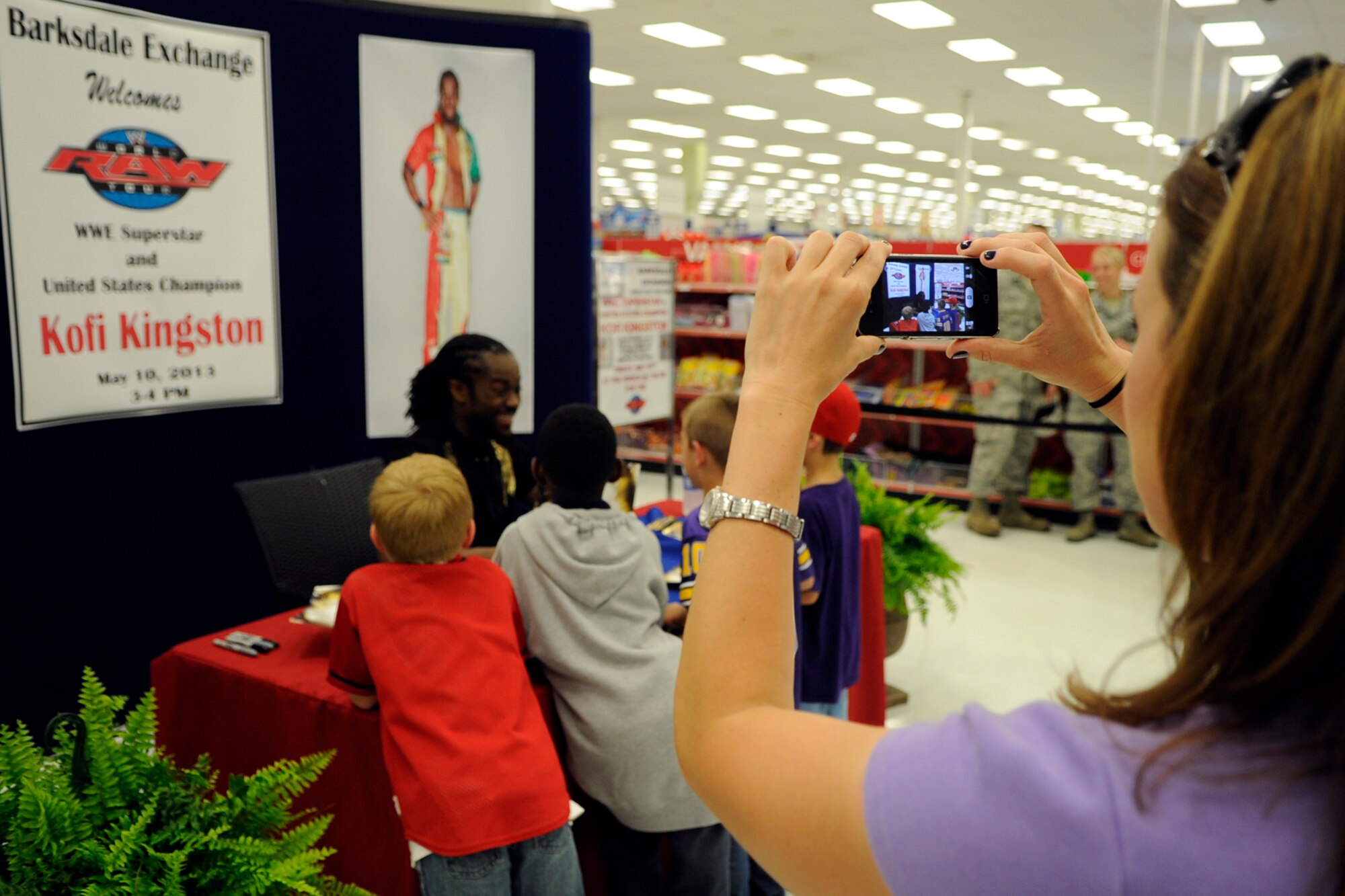Senior Master Sgt. Melissa Hubbard, first sergeant, 307th Civil Engineer Squadron, takes a photo of her son and a few of his friends, who she escorted to see  WWE Superstar and United States Champion Kofi Kingston, during a “meet and greet the troops” event at the Base Exchange on Barksdale Air Force Base, La., May 10, 2013. Later that evening, Kingston defeated Cody Rhodes during a WWE Smackdown event at the Hirsch Memorial Coliseum in Shreveport, La. (U.S. Air Force photo by Master Sgt. Jeff Walston/Released)