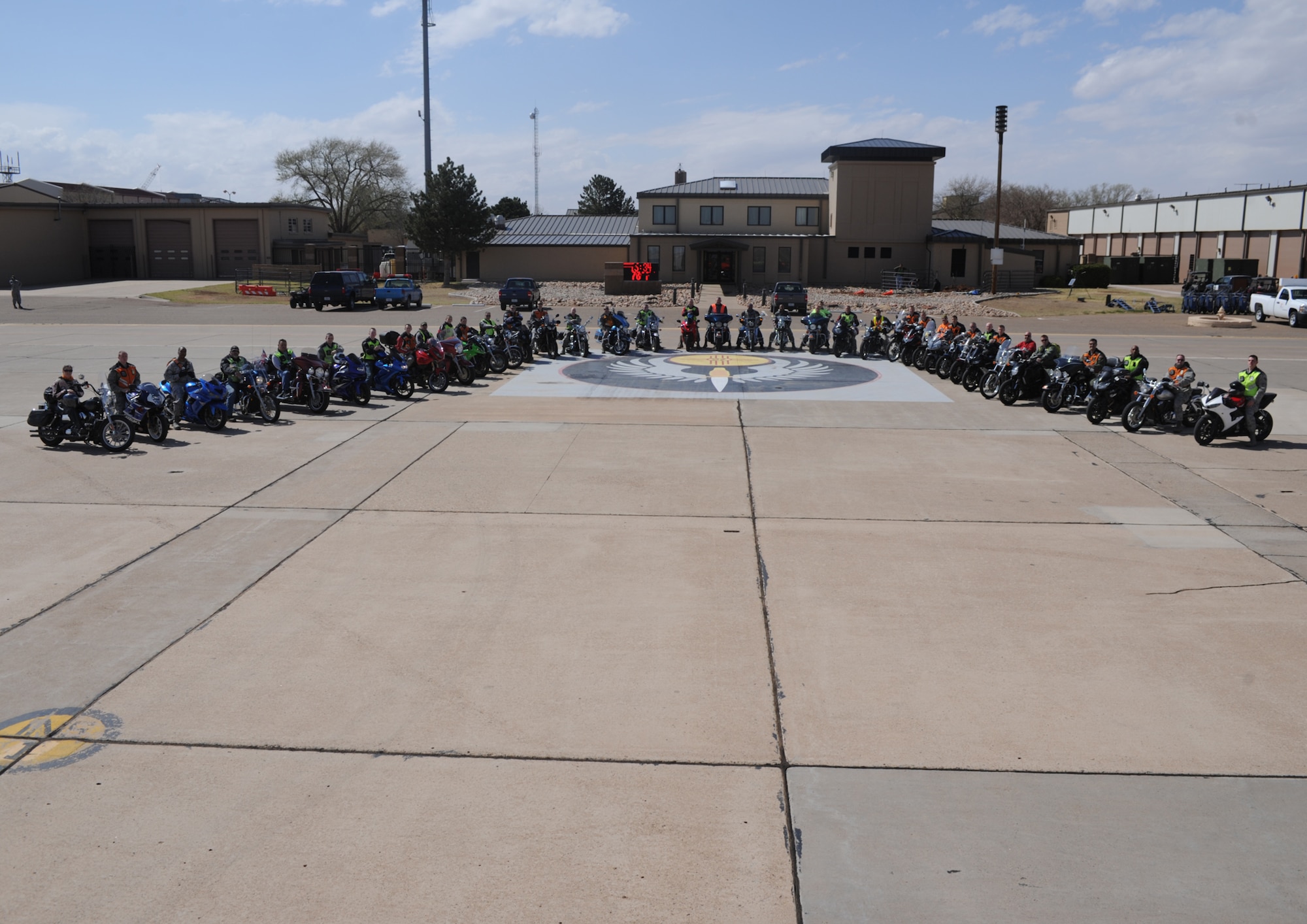 A group of motorcyclists gather outside base operations after the second annual Runway Ride at Cannon Air Force Base, N.M., May 6, 2013. The ride consisted of a group trip around the base and down the runway, ending in a group photo on the flightline. (U.S. Air Force photo/Senior Airman Ericka Engblom)