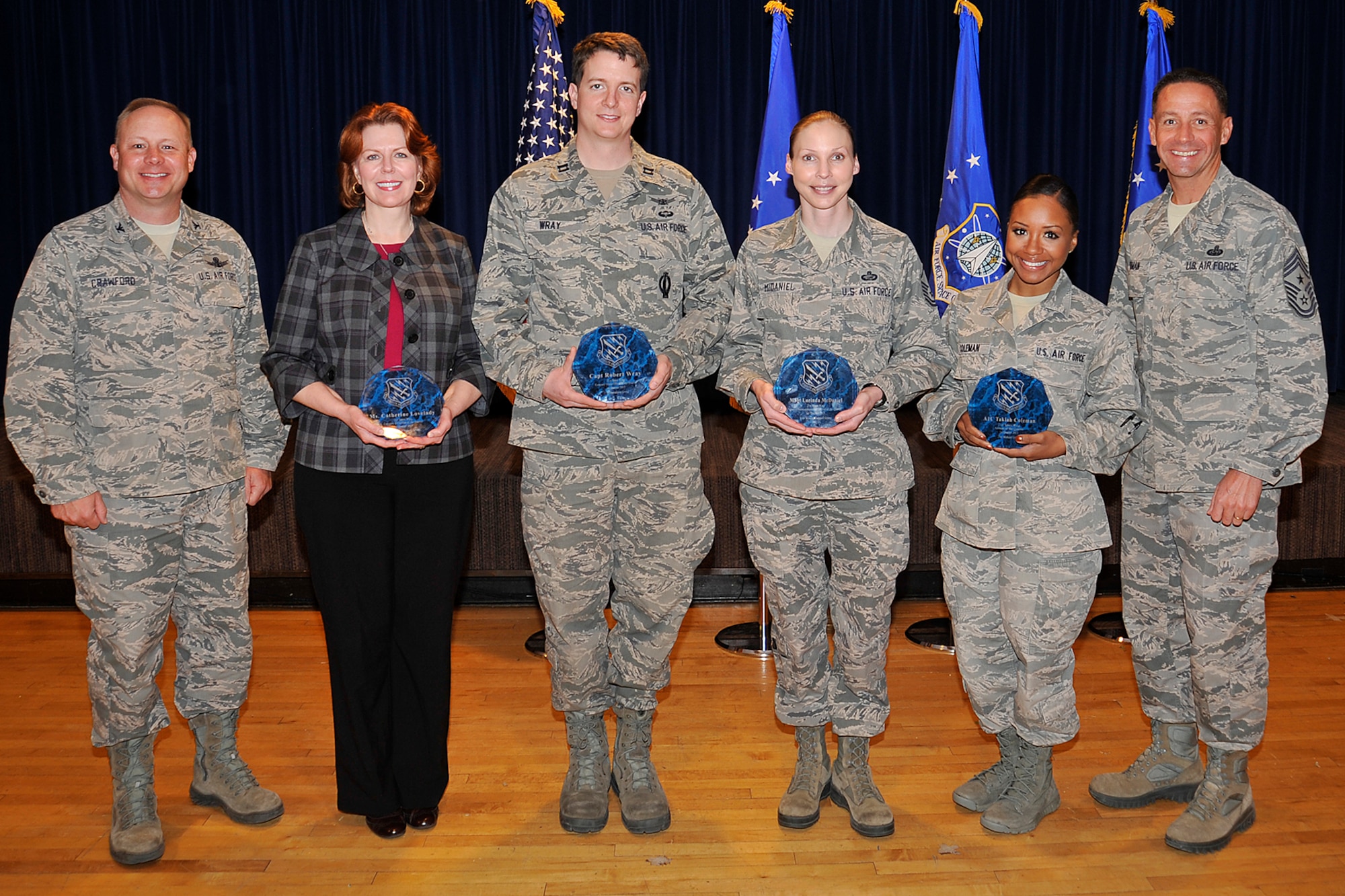 PETERSON AIR FORCE BASE, Colo. – The 21st Space Wing held its quarterly awards breakfast May 7 at The Club. Col. Chris Crawford (left), 21st Space Wing commander and Chief Master Sgt. Richard Redman (right), 21st SW command chief, presented awards to Catherine Lovelady, 21st Mission Support Group, Category II Civilian of the quarter; Capt. Robert Wray, 21st Operations Group, Company Grade Officer of the quarter; Master Sgt. Lorinda McDaniel, 21st MSG, Senior NCO of the quarter; and Airman 1st Class Takiah Coleman, 21st Medical Group, Airman of the quarter. Winners not present included Tech. Sgt. Michael Skonetski, 821st Air Base Group, NCO of the quarter; Evangelina Horario, 21st MDG, Category I Civilian of the quarter; and Michael McKinion, 21st OG, Category III Civilian of the quarter. (U.S. Air Force photo/Dennis Howk)