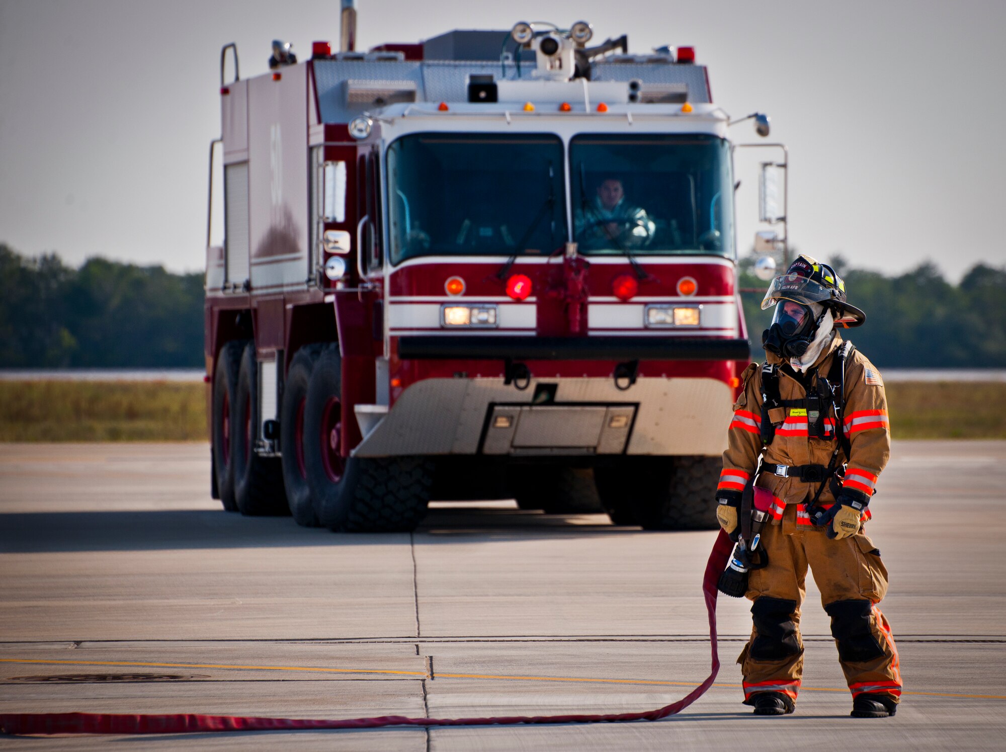 An Eglin Air Force Base firefighter stands by to engage the fire from an F-35 Lightning II during a major accident response exercise May 9.  This was the first MARE involving the Air Force’s newest fighter aircraft at Eglin.  First responders had to put out fires on debris from the aircraft after a hard landing.  They also had to extract the injured pilot and get him to medical personnel.  (U.S. Air Force photo/Samuel King Jr.)