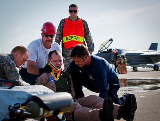 Eglin Air Force Base firefighters and medical technicians prepare to move an injured F-35 Lightning II pilot during a major accident response exercise May 9.  This was the first MARE involving the Air Force’s newest fighter aircraft at Eglin.  First responders had to put out fires on debris from the aircraft after a hard landing.  They also had to extract the injured pilot and get him to medical personnel.  (U.S. Air Force photo/Samuel King Jr.)