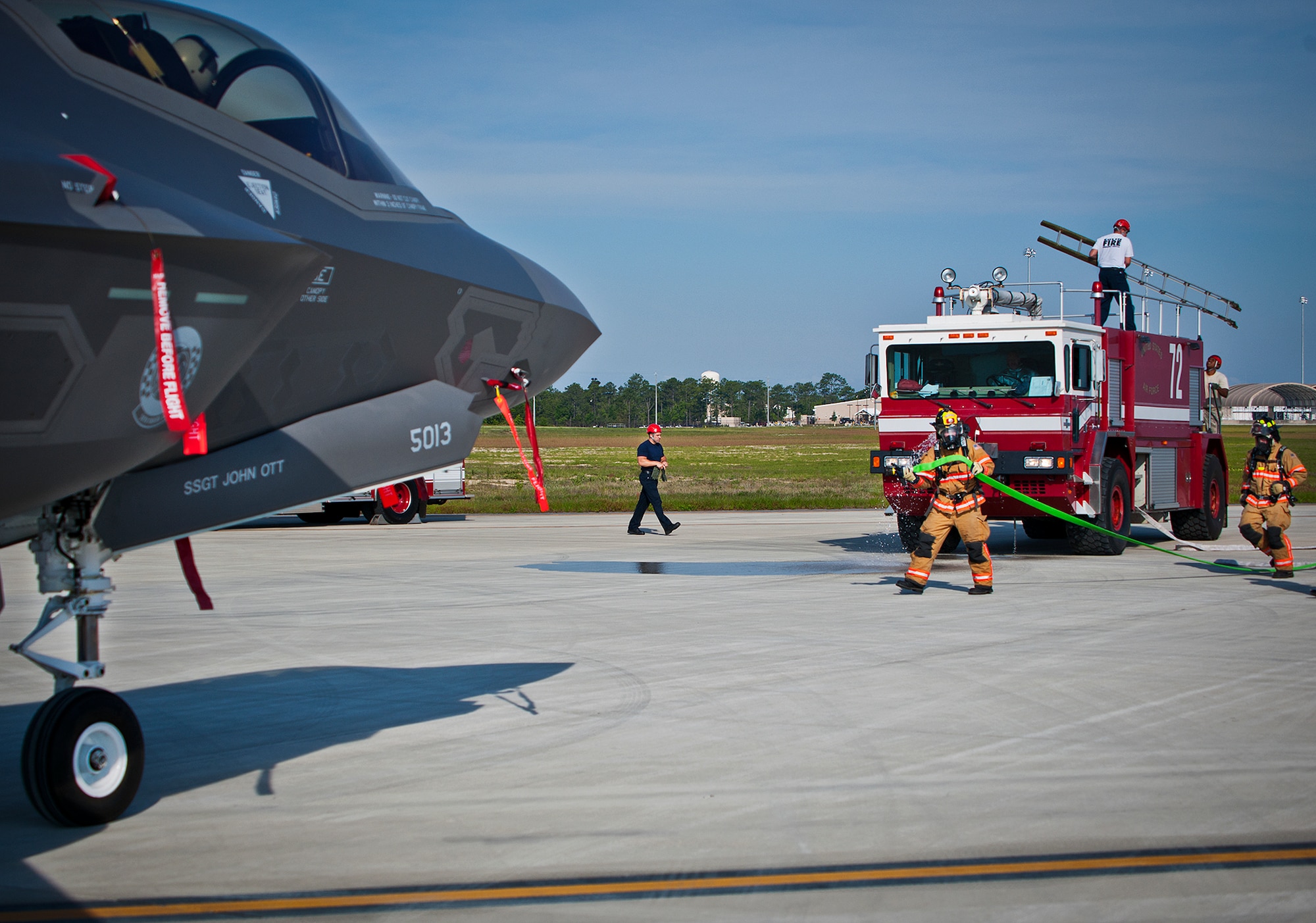 Eglin Air Force Base firefighters move toward a 33rd Fighter Wing F-35 Lightning II during a major accident response exercise May 9.  This was the first MARE involving the Air Force’s newest fighter aircraft at Eglin.  First responders had to put out fires on debris from the aircraft after a hard landing.  They also had to extract the injured pilot and get him to medical personnel.  (U.S. Air Force photo/Samuel King Jr.)