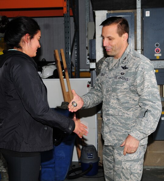 From left, Airman 1st Class Karla Rosas, 100th Security Forces Squadron member from Chicago, receives a commander’s coin from Col. Christopher Kulas, 100th Air Refueling Wing commander, May 9, 2013, after she returned home to RAF Mildenhall, England, from a six-month deployment. Rosas was coined by Kulas on behalf of Brig. Gen. Steven Shepro, 438th Air Expeditionary Wing commander, after she won the 438th AEW Airman of the Quarter Award at her deployed location. (U.S. Air Force photo by Karen Abeyasekere/Released)