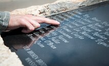 An airman looks through the names of the 22 instructor pilots from the 3645th Pilot Training Squadron, whom were killed in Southeast Asia during the Vietnam War, carved on a memorial at Ribas-Dominicci Circle at Laughlin Air Force Base, Texas, May 8, 2013. A memorial dedication ceremony is scheduled for May 31, 2013. (U.S. Air Force photo/Airman 1st Class John D. Partlow)