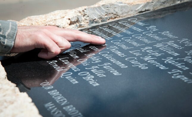 An airman looks through the names of the 22 instructor pilots from the 3645th Pilot Training Squadron, whom were killed in Southeast Asia during the Vietnam War, carved on a memorial at Ribas-Dominicci Circle at Laughlin Air Force Base, Texas, May 8, 2013. A memorial dedication ceremony is scheduled for May 31, 2013. (U.S. Air Force photo/Airman 1st Class John D. Partlow)