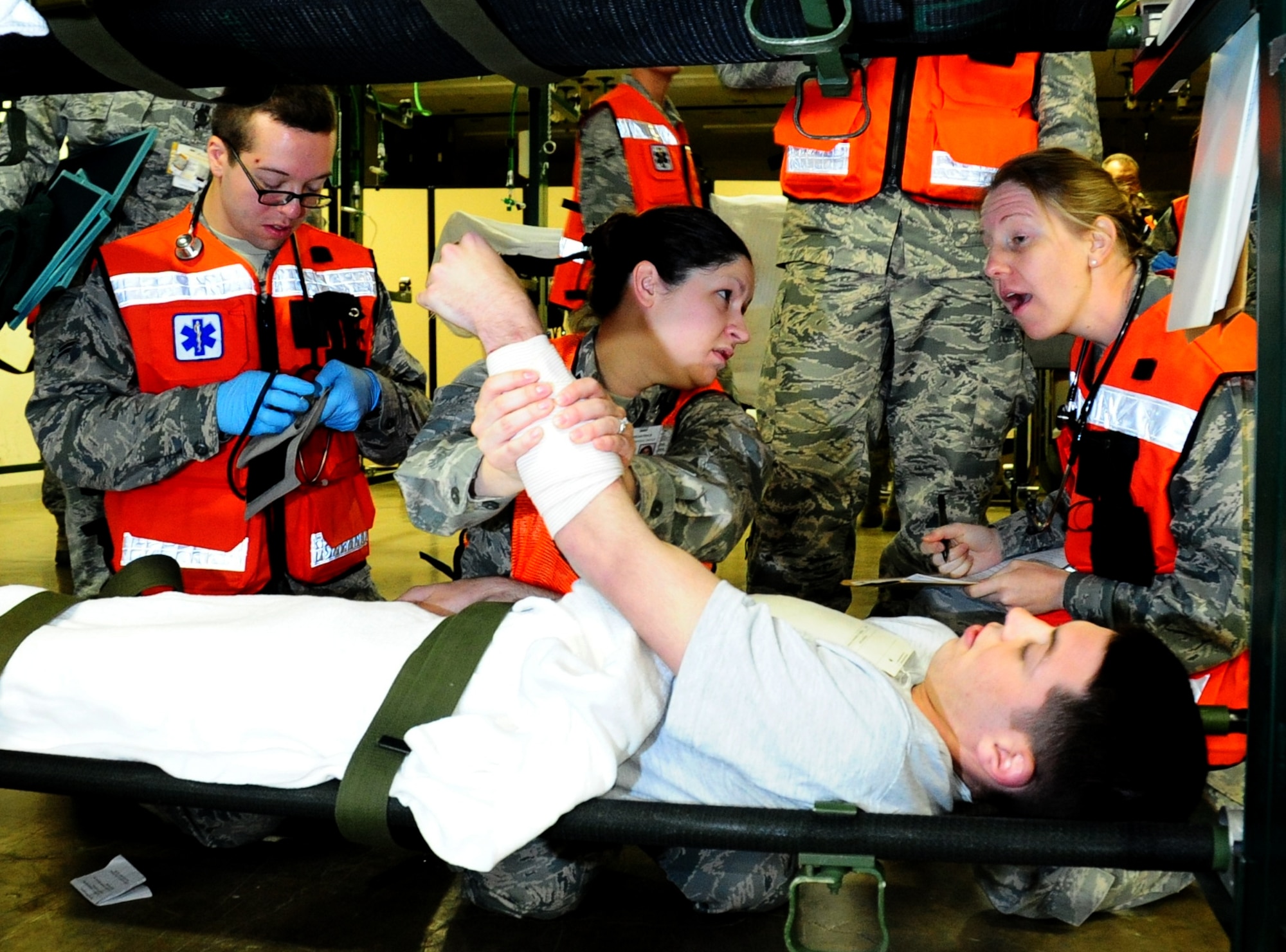 U.S. Air Force Capt. Katie Ellgass (right), Capt. Julie Airhart (center) and A1C Jared Campbell, all members of the 35th Medical Group, assess a  simulated victim's injuries and prepare him for treatment during a base Emergency Management Exercise at Misawa Air Base, Japan, May 13, 2013. The EME ensured the medical technicians were proficient in their operational readiness capabilities.  (U. S. Air Force photo by Staff Sgt. April Quintanilla)