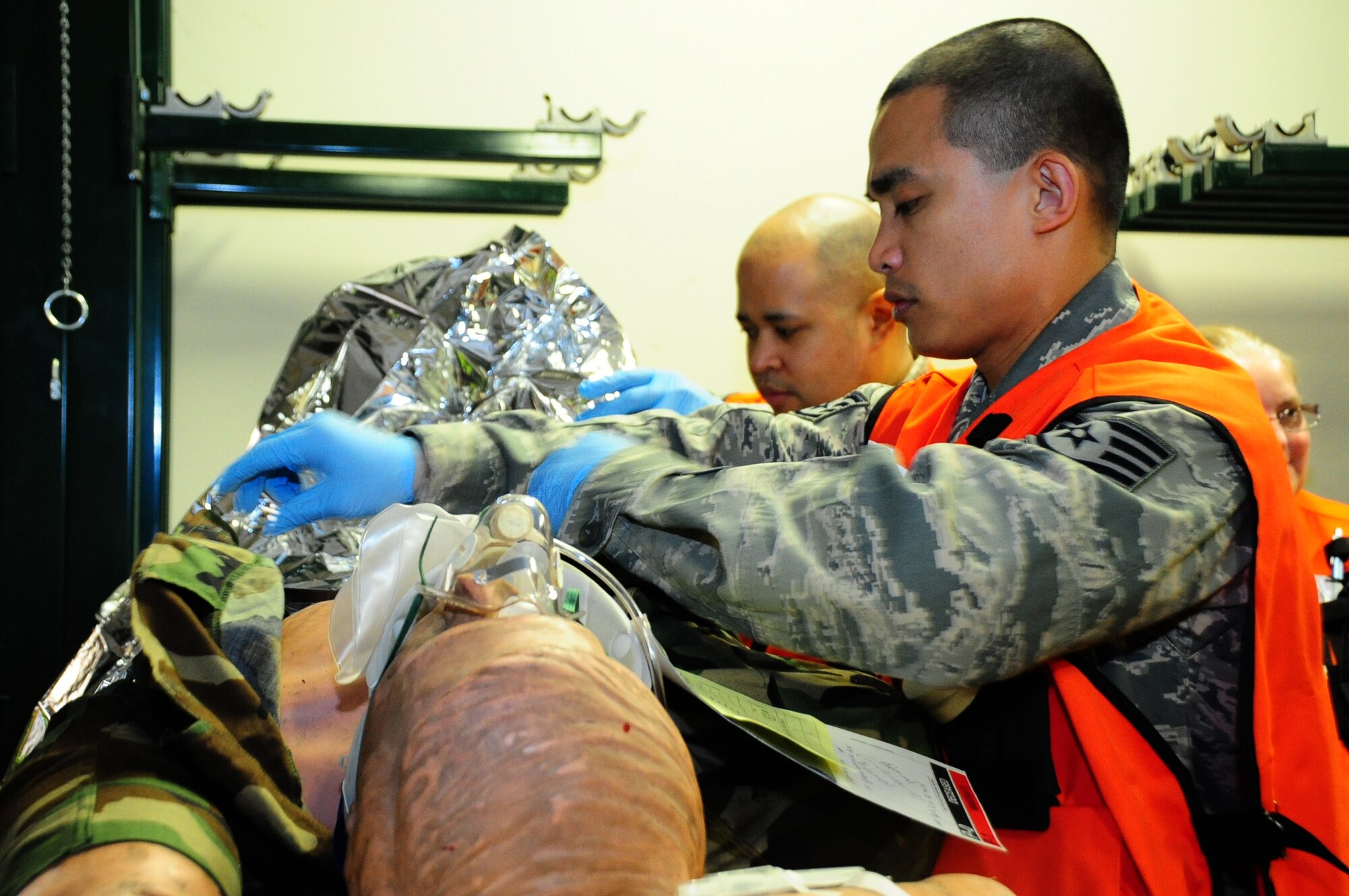 U.S. Air Force Staff Sgt. Earvin Bundang, 35th Medical Group emergency management technician, exposes the simulated victim's injuries and prepares him for treatment during a during a base Emergency Management Exercise at Misawa Air Base, Japan, May 13, 2013. The EME ensured medical technicians were proficient in their operational readiness capabilities.  (U. S. Air Force photo by Staff Sgt. April Quintanilla))