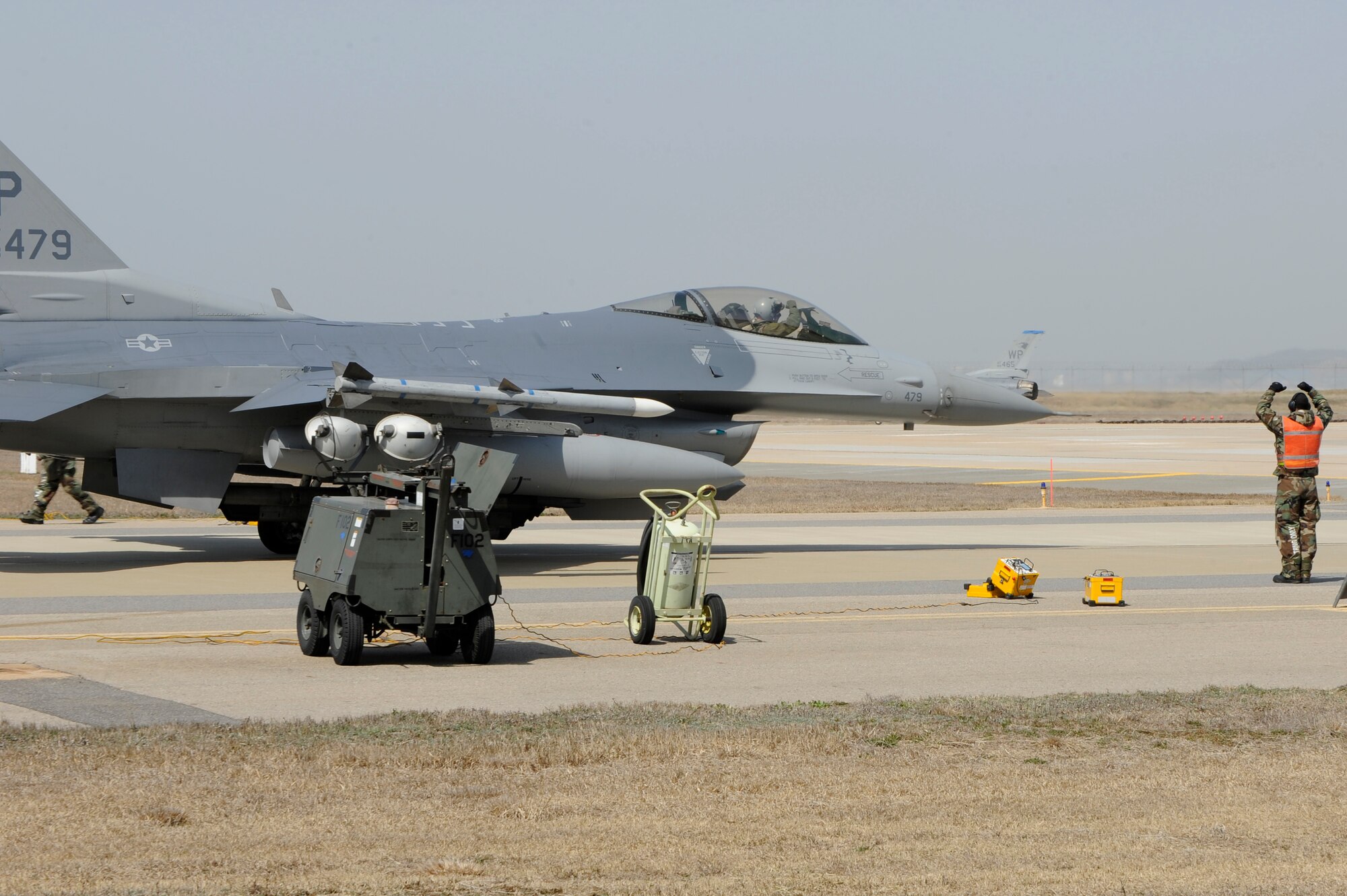 KUNSAN AIR BASE, Republic of Korea -- An Airman from the 8th Aircraft Maintenance Squadron marshals an F-16 Fighting Falcon into position for a final inspection during exercise Beverly Bearcat 13-01 at Kunsan Air Base, Republic of Korea, April 9, 2013. The exercise was designed to test the base’s operational readiness for its mission. (U.S. Air Force photo by Senior Airman Marcus Morris/Released)