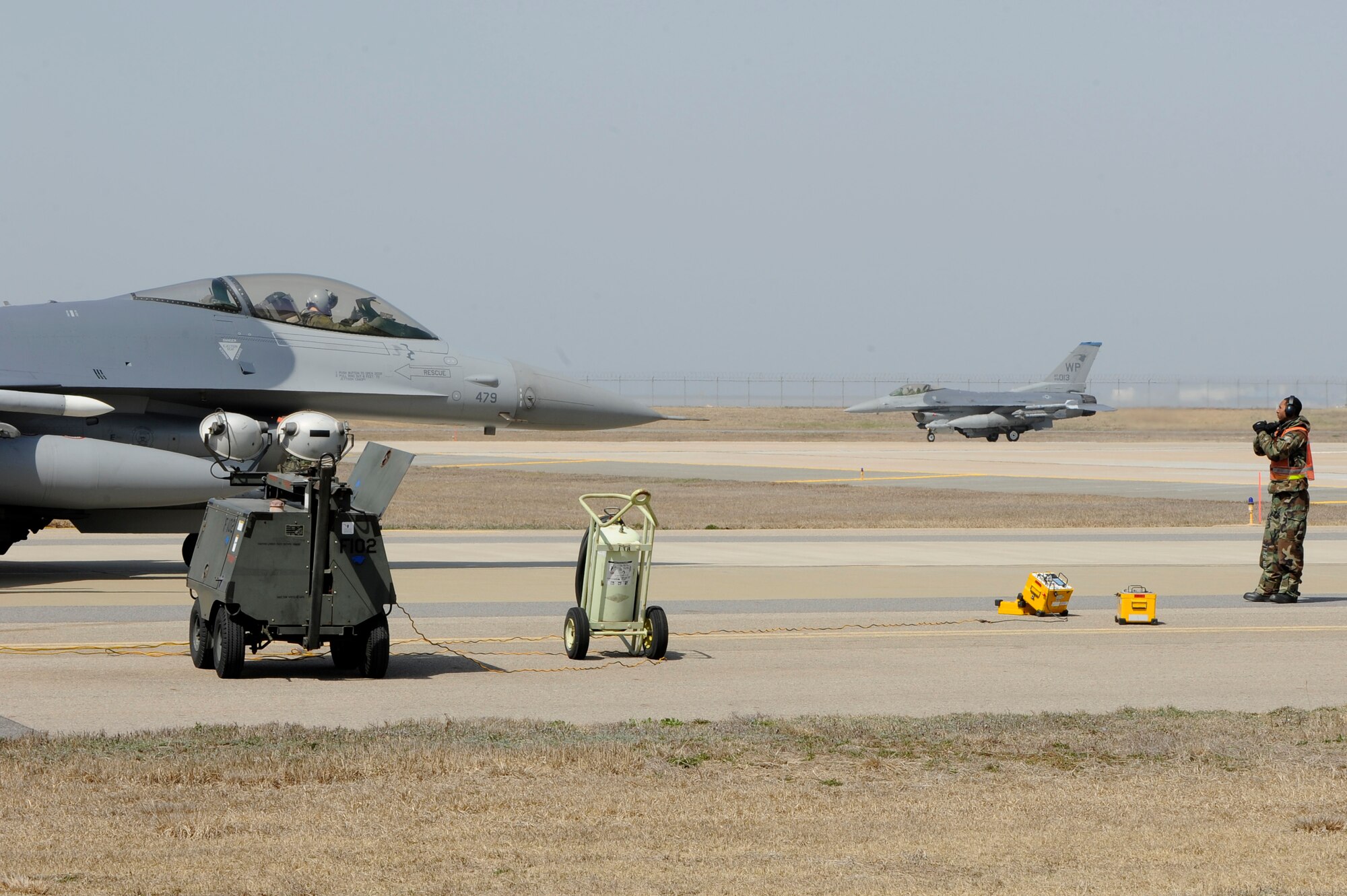 KUNSAN AIR BASE, Republic of Korea -- An Airman from the 8th Aircraft Maintenance Squadron guides an F-16 Fighting Falcon into position for a final inspection during exercise Beverly Bearcat 13-01 at Kunsan Air Base, Republic of Korea, April 9, 2013. The exercise showcased Kunsan AB aircrew capability to quickly and safely prepare an aircraft for a mission. (U.S. Air Force photo by Senior Airman Marcus Morris/Released)