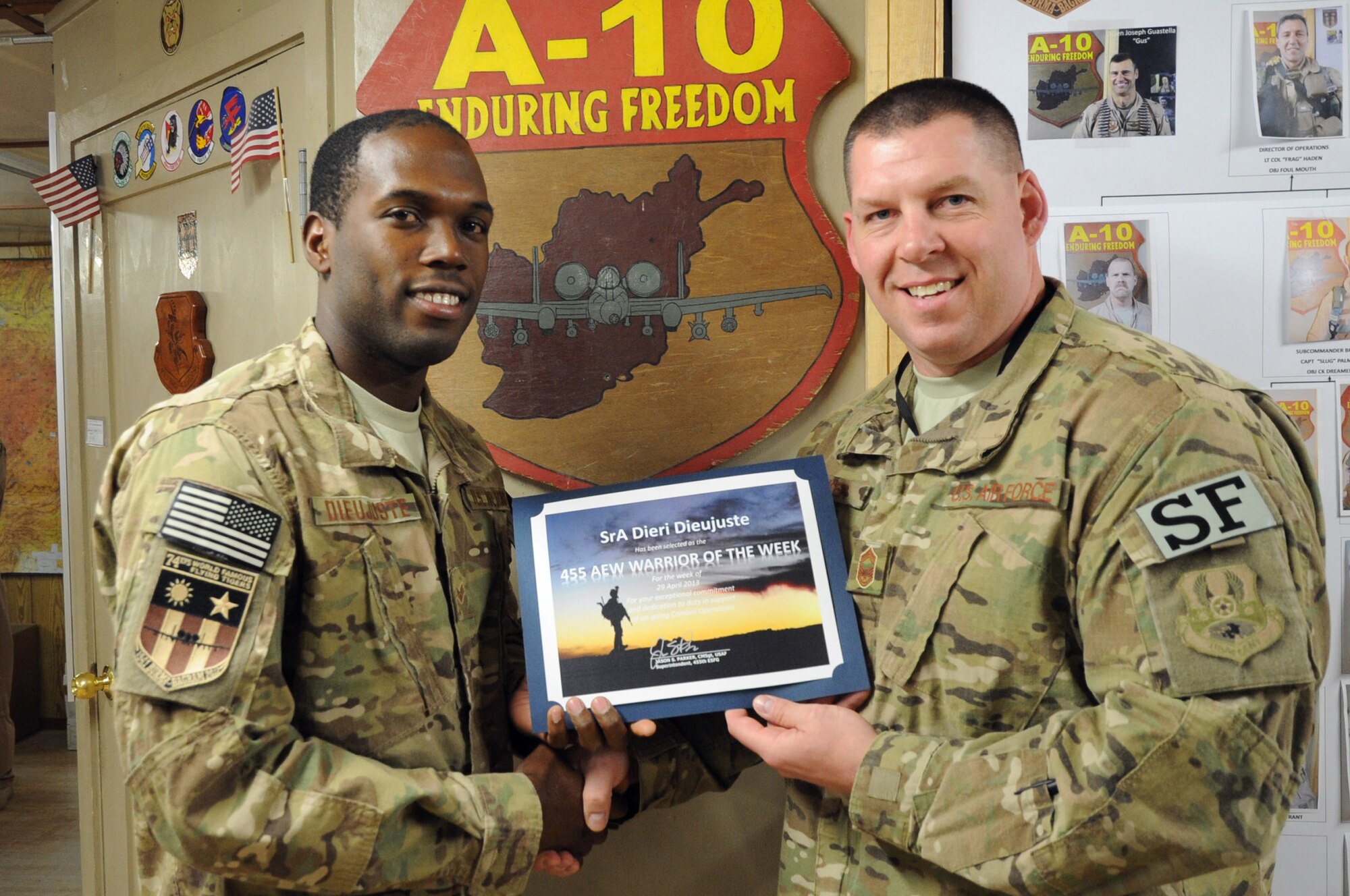 Chief Master Sgt. Jason Parker, 455th ESFG superintendent, presents the "Warrior of the Week" award to Senior Airman Dieri Dieujuste, 74th Expeditionary Fighter Squadron aircrew flight equipment specialist, on Bagram Airfield, May 8, 2013. Dieujuste supported more than 360 combat sorties and is one of the first Airmen to be qualified on the Helmet-Mounted Integrated Targeting System for A-10 pilots. (U.S. Air Force photo/Staff Sgt. David Dobrydney)