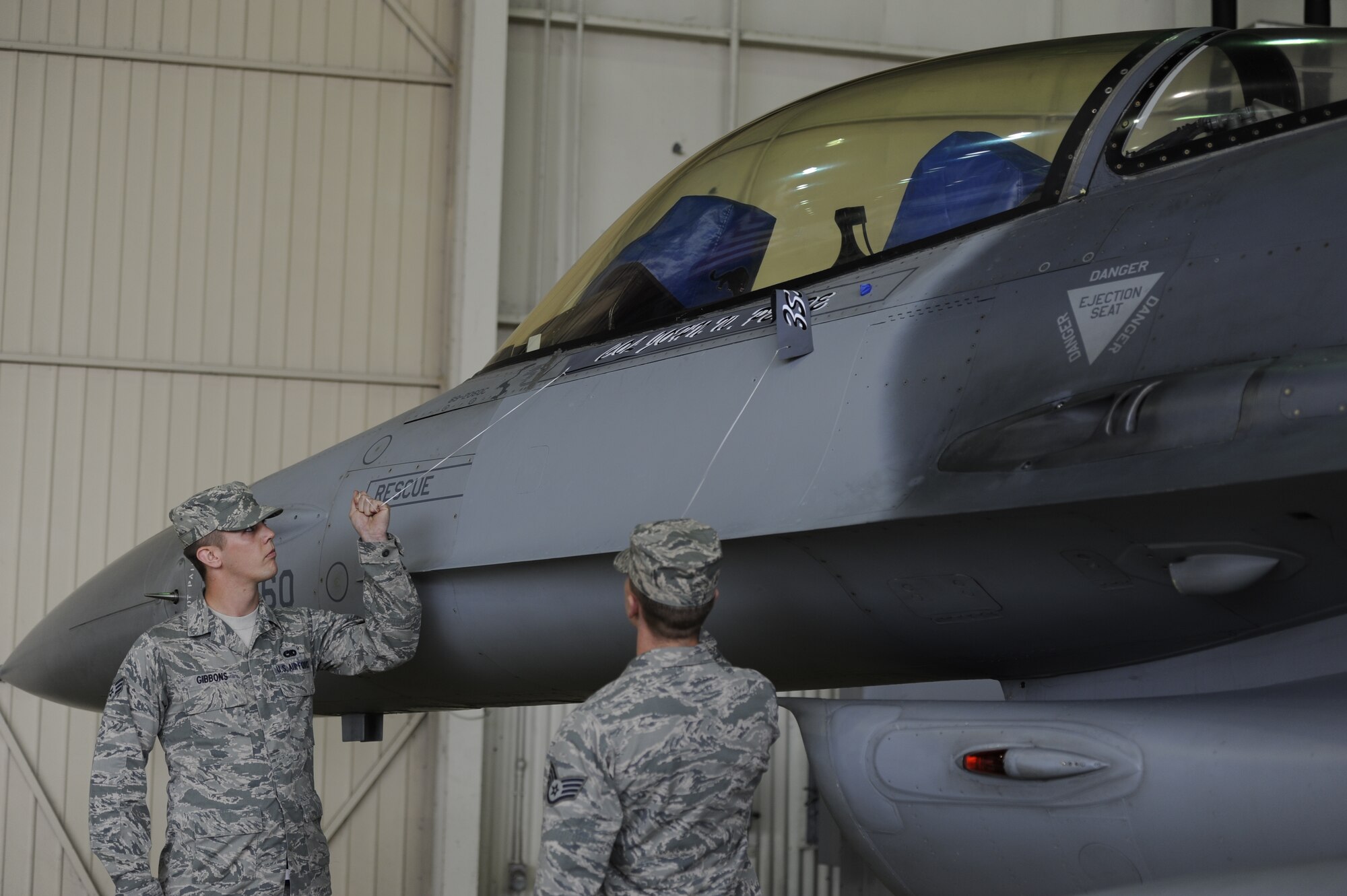 KUNSAN AIR BASE, Republic of Korea -- Staff Sgt. Nicholas Filer and Senior Airman Grant Gibbons, 8th Aircraft Maintenance Squadron dedicated crew chiefs, remove Col. John W. Pearse’s name from the 8th Fighter Wing commander’s aircraft to reveal Col. S. Clinton Hinote’s name during a change of command ceremony at Kunsan Air Base, Republic of Korea, May 10, 2013. Hinote, “Wolf 53” assumed command of the Wolf Pack from the outgoing commander, Pearse. (U.S. Air Force photo by Staff Sgt. Tong Duong/ Released)  