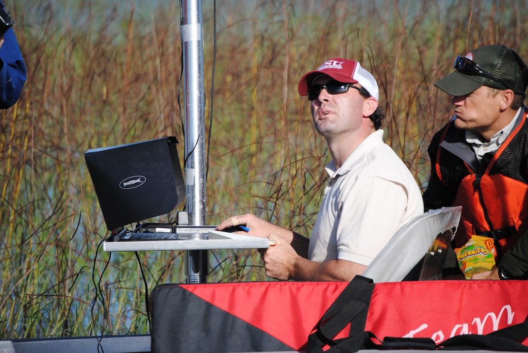 Jon Morton, Biologist with Jacksonville District, looks up from his ground station to track the NOVA Unmanned Ariel Vehicle (UAV) as it flies over his boat.  Morton was leading a Corps team using the NOVA to get photos from the air above Lake Okeechobee in November. 