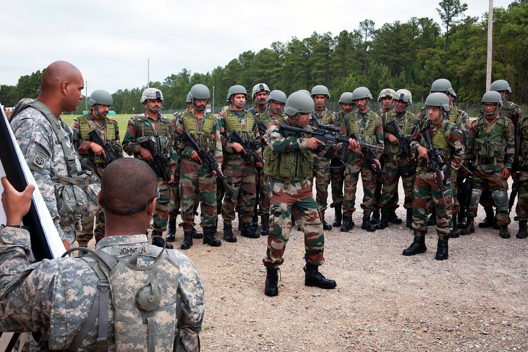 Indian army Maj. Arvind Singh, center, demonstrates how to shoulder an M4 carbine to his soldiers before sighting in the weapon at a range during Yudh Abhyas 2013 on Fort Bragg, N.C., May 4, 2013. Singh, a company commander, is assigned to the 50th Independent Para Brigade.