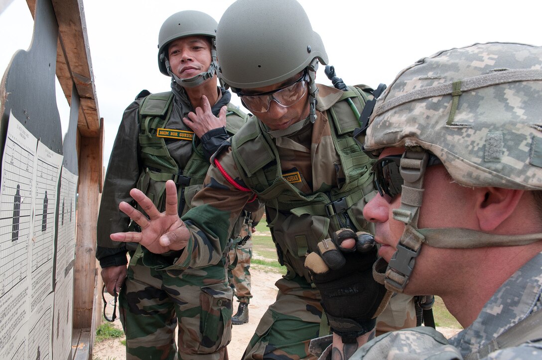 An Indian army soldier confirms the adjustment needed to the scope of his M4 carbine with a U.S. Army paratrooper at a range during Yudh Abhyas 2013 on Fort Bragg, N.C., May 4, 2013.