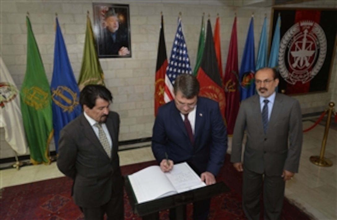 Deputy Secretary of Defense Ashton B. Carter, center, signs the guestbook as he arrives for a meeting at the Afghanistan Ministry of Defense in Kabul, Afghanistan, on May 12, 2013.  First Deputy Minister of Defense for Afghanistan Enayatullah Nazari, right, and Afghan Ministry of Defense Spokesman Zaher Azimi, left, watch as their guest signs the book.  